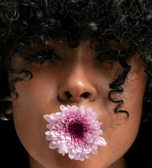 Mulher com cabelos cacheados valorizando a beleza natural dos fios e a proposta de praticidade do Curly.